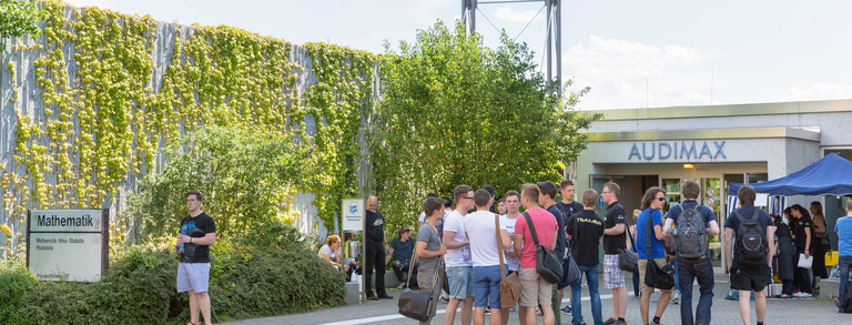 Studierende stehen auf dem Vorplatz am Audimax. 